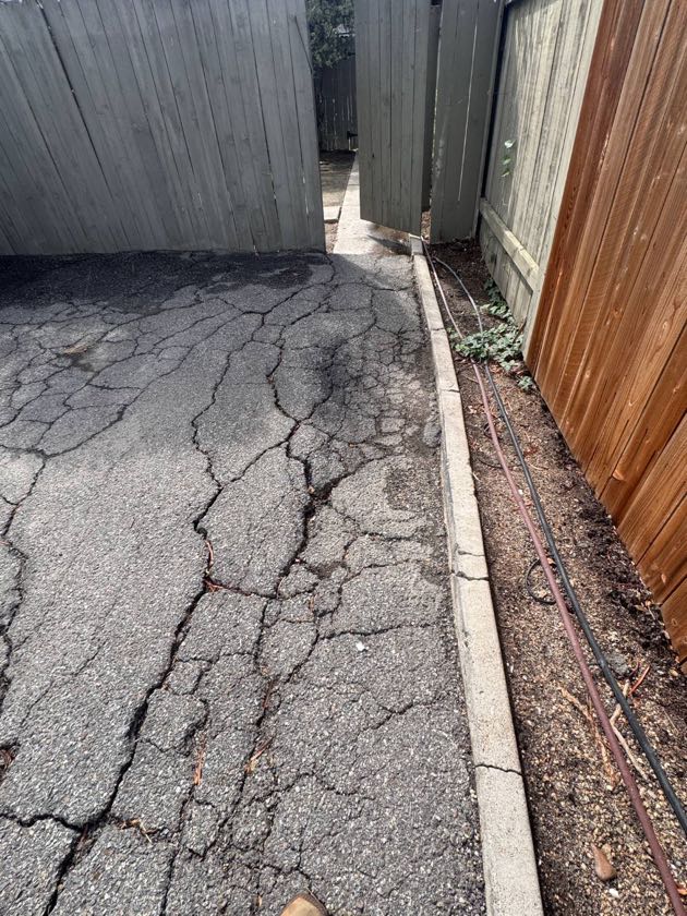 Before: cracked asphalt along a walkway in Costa Mesa