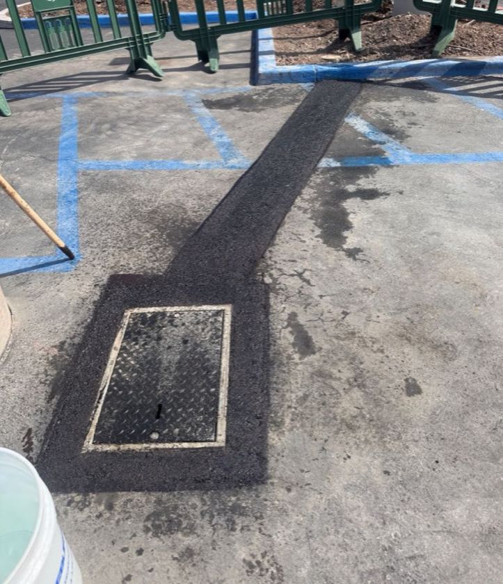 Finished asphalt trench patch next to ADA parking stalls in Irvine, CA